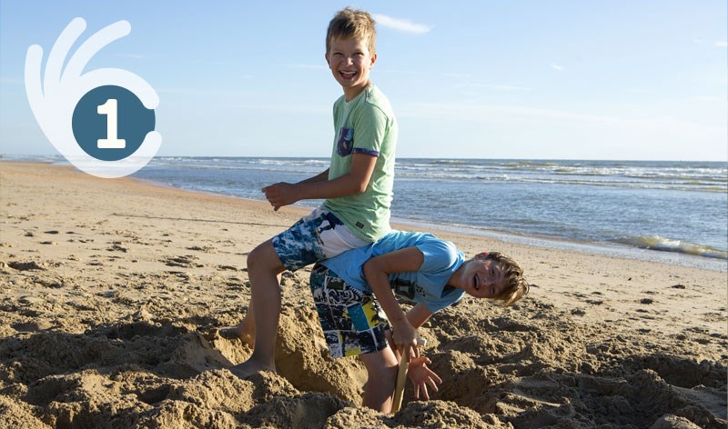 Jongens spelen op het strand