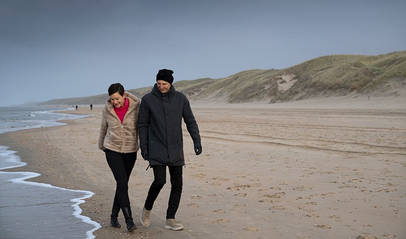 Wandelend stel op het strand van Castricum aan Zee in de winter